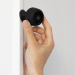 Hand som håller i en övervakningskamera