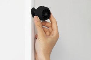 Hand som håller i en övervakningskamera